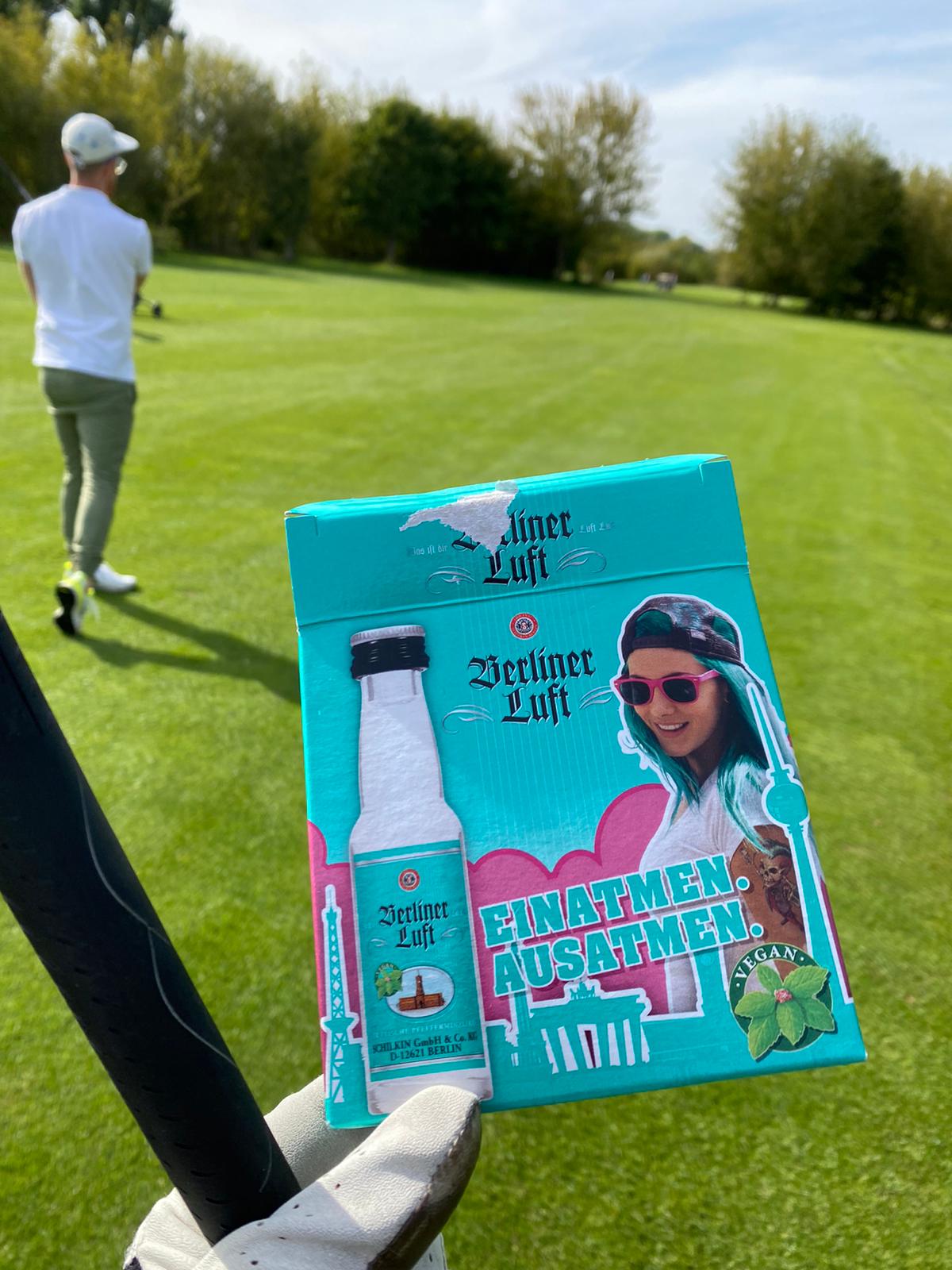 Berliner-Luft-Kiste auf dem Fairway, im Hintergrund ein Spieler
