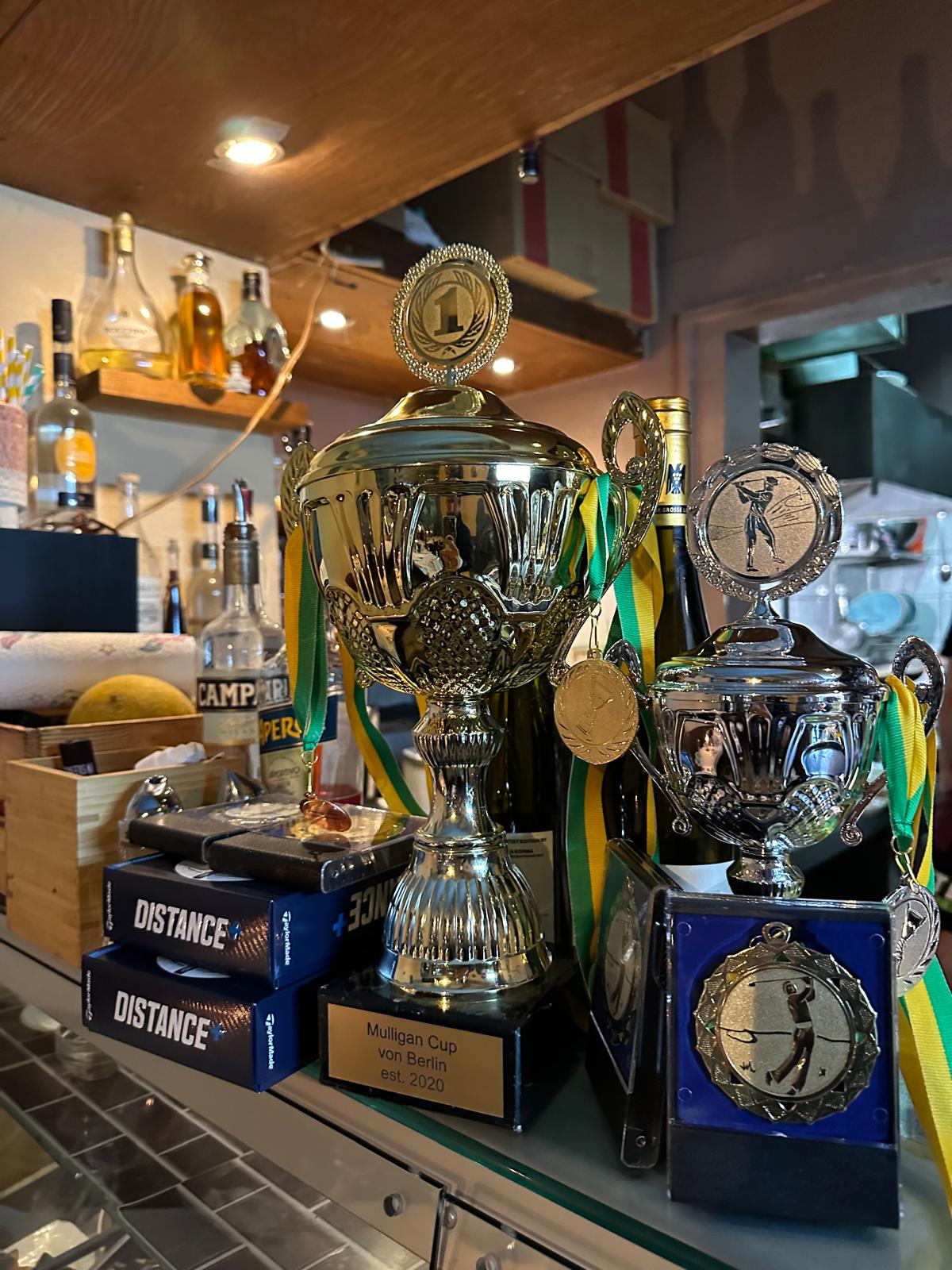 Pokale und Medaillen des Mulligan Cup von Berlin, est. 2020, an der Clubhaus-Bar